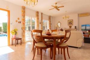 sala de estar con mesa de madera y sillas en Villa Henri spacious 6P villa with private pool, en Mutxamel
