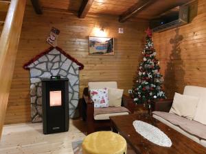 a living room with a christmas tree and a fireplace at Zara Chalet in Kolašin