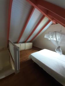 a bedroom with a white bed and a red ceiling at La petite maison dans la prairie in Gros-Morne