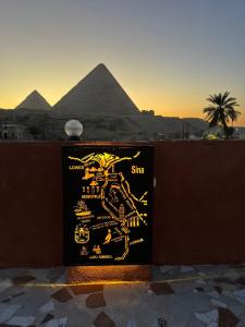 een bord met de piramides op de achtergrond bij El Khalil Pyramids Inn in Caïro