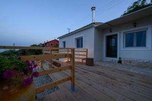 a wooden deck in front of a house at Kalyva Country House, with private beach and pool in Benitses