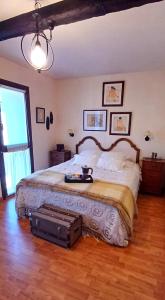 um quarto com uma cama grande com uma mala no chão em Molino21 Castiello de Jaca em Castiello de Jaca