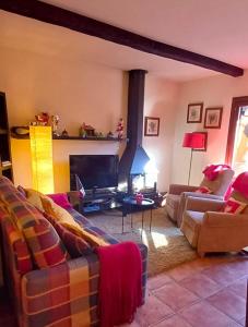 uma sala de estar com dois sofás e uma televisão em Molino21 Castiello de Jaca em Castiello de Jaca