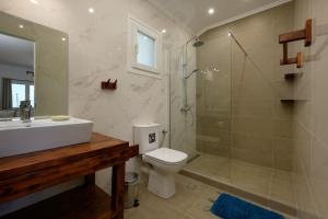 a bathroom with a shower and a toilet and a sink at Kalyva Country House, with private beach and pool in Benitses