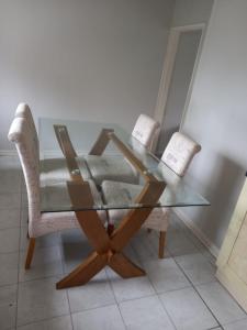 uma mesa de jantar de vidro e duas cadeiras num quarto em Amazing 3 bedroom house with parking. em Nottingham