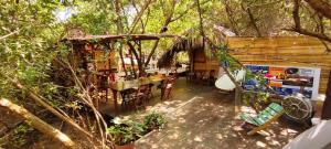 a patio with a table and chairs and a house at Cabaña Corazon Mazunte in Mazunte