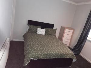 a bedroom with a bed and a dresser at Amazing 3 bedroom house with parking. in Nottingham