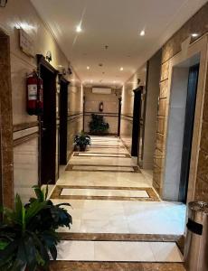 a hallway of a building with plants on the floor at لجين الجوهرة للوحدات المخدومة in Al ‘Azīzīyah