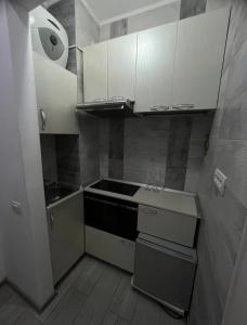 a small kitchen with white cabinets and a sink at Amazing location in the city center in Bucharest