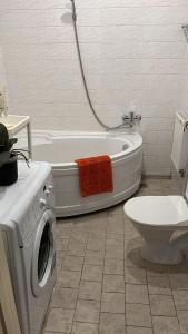een badkamer met een bad en een wasmachine bij Riga Central District, Тихий Центр города, всё под боком, удобно in Rīga