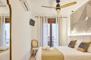 um quarto com uma cama e uma ventoinha de tecto em Little Arboli Little Apartments em Cádiz