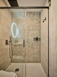 um chuveiro com uma porta de vidro na casa de banho em Little Arboli Little Apartments em Cádiz