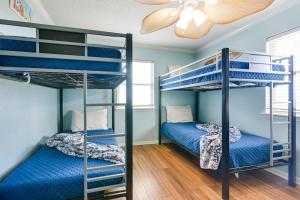 two bunk beds in a room with blue walls at 'Coastal Retreat: 'Sea Dreams Beach House' in Freeport