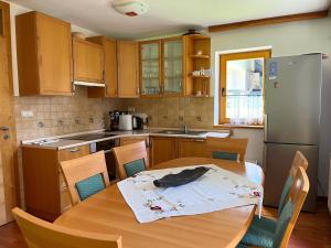 a kitchen with a wooden table and a refrigerator at Chalet Harmony Rogla - apartment in Zreče
