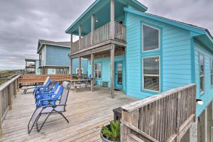 a blue house with chairs on a wooden deck at 'Coastal Retreat: 'Sea Dreams Beach House' in Freeport