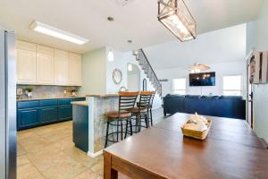 a kitchen with blue cabinets and a wooden table at 'Coastal Retreat: 'Sea Dreams Beach House' in Freeport