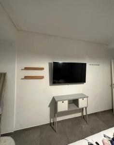 sala de estar con TV en una pared blanca en Depto temporario en Corrientes