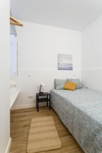 Habitación blanca con 2 camas y mesa en Apt + patio privado Atocha Delicias Madrid Rio, en Madrid