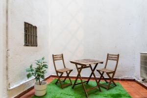 uma mesa e duas cadeiras sentadas ao lado de uma parede em Apt + patio privado Atocha Delicias Madrid Rio em Madrid