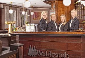 a group of women standing behind a bar at Hotel Restaurant Waldesruh in Emstek