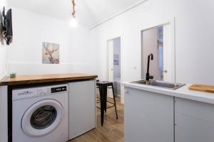 uma cozinha com uma máquina de lavar roupa e um lavatório em Apt + patio privado Atocha Delicias Madrid Rio em Madrid