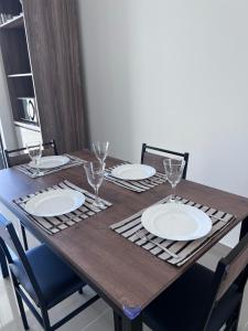 - une table en bois avec des assiettes et des verres à vin dans l'établissement Brisas de São Chico - 450m da Praia, à São Francisco do Sul