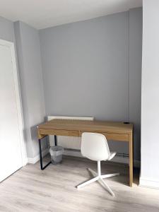 een bureau en een witte stoel in een kamer bij Smithdown Rooms in Liverpool