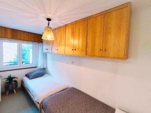 a room with a bed and wooden cabinets at ''Chalet'' au Centre et Parking Couvert GRATUIT in Veysonnaz