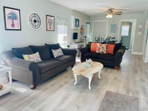 a living room with two couches and a coffee table at Beach House in Oceanlakes Campgrounds Myrtle Beach, South Carolina in Myrtle Beach