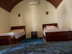 two beds in a room with a room with at انتيكا كامب in Taba