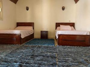 two beds in a room with two rugs at انتيكا كامب in Taba +8 photos
