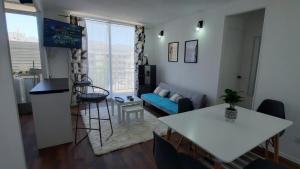 a living room with a blue couch and a table at Lindo departamento central in Ovalle