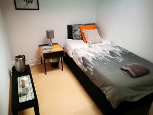 Schlafzimmer mit einem Bett und einem Beistelltisch in der Unterkunft THE EDINBURGH TOWNHOUSE - Boutique Hostel in Edinburgh
