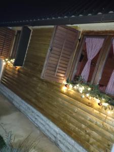 a porch with christmas lights and a window at Kuća za odmor Antonija in Gospić