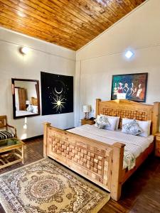 a bedroom with a large wooden bed and a mirror at Umda Hotel Pine Top in Murree