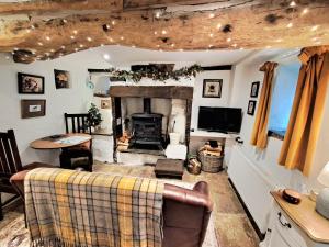 a living room with a fireplace and a couch at Beebole Cottage in Askrigg