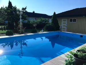 una piscina de agua azul en un patio en Villa with pool and sauna, en Porsgrunn