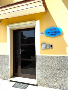 een gebouw met een deur met een bord erop bij B&B Lamezia Central Airport in SantʼEufemia Lamezia