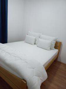 a white bed with white sheets and pillows at Apartman Diva in Belgrade