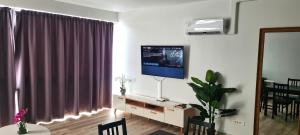 a living room with a television on a wall at Appartement F2 Ninirei in Papeete