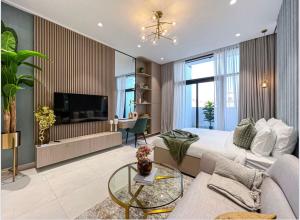 een slaapkamer met een bed, een bank en een tv bij Luxury New Studio with Pool & Gym Access, 5 min from Gardens Metro in Dubai