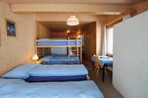 a room with two bunk beds and a desk at Berghotel Distelboden in Frutt