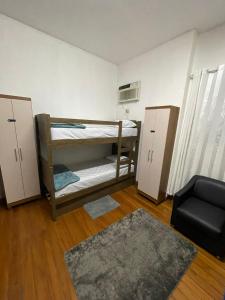 a small room with two bunk beds and a chair at Garden Hostel - Santana in Sao Paulo