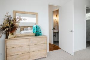 a bedroom with a dresser with a mirror on it at Beachside Mornington house in Mornington