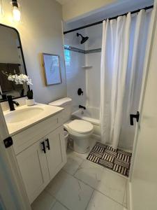 La salle de bains blanche est pourvue d'une douche et de toilettes. dans l'établissement Cozy Mountain Escape, à Salt Lake City