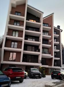 a parking lot in front of a tall building at Apartment - Vucica in Bjelašnica +42 photos