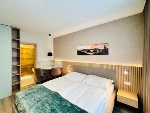 a bedroom with a large bed and a desk at Hotel Tyrapol - Smrek Apartments in Oravská Lesná