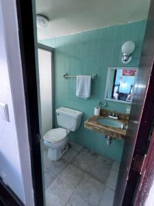 a bathroom with a toilet and a sink and a mirror at Hotel Santa Barbara in Mazatlán