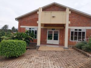une maison en briques rouges avec une porte blanche dans l'établissement Centre d'Accueil Bonne Esperance Rwanda, à Kigali