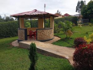 - un kiosque avec une table et des chaises dans la cour dans l'établissement Centre d'Accueil Bonne Esperance Rwanda, à Kigali